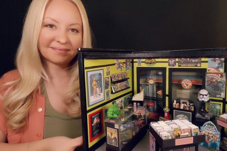 Bridget holds one of her miniature set creations, the comic book store from the show The Big Bang Theory