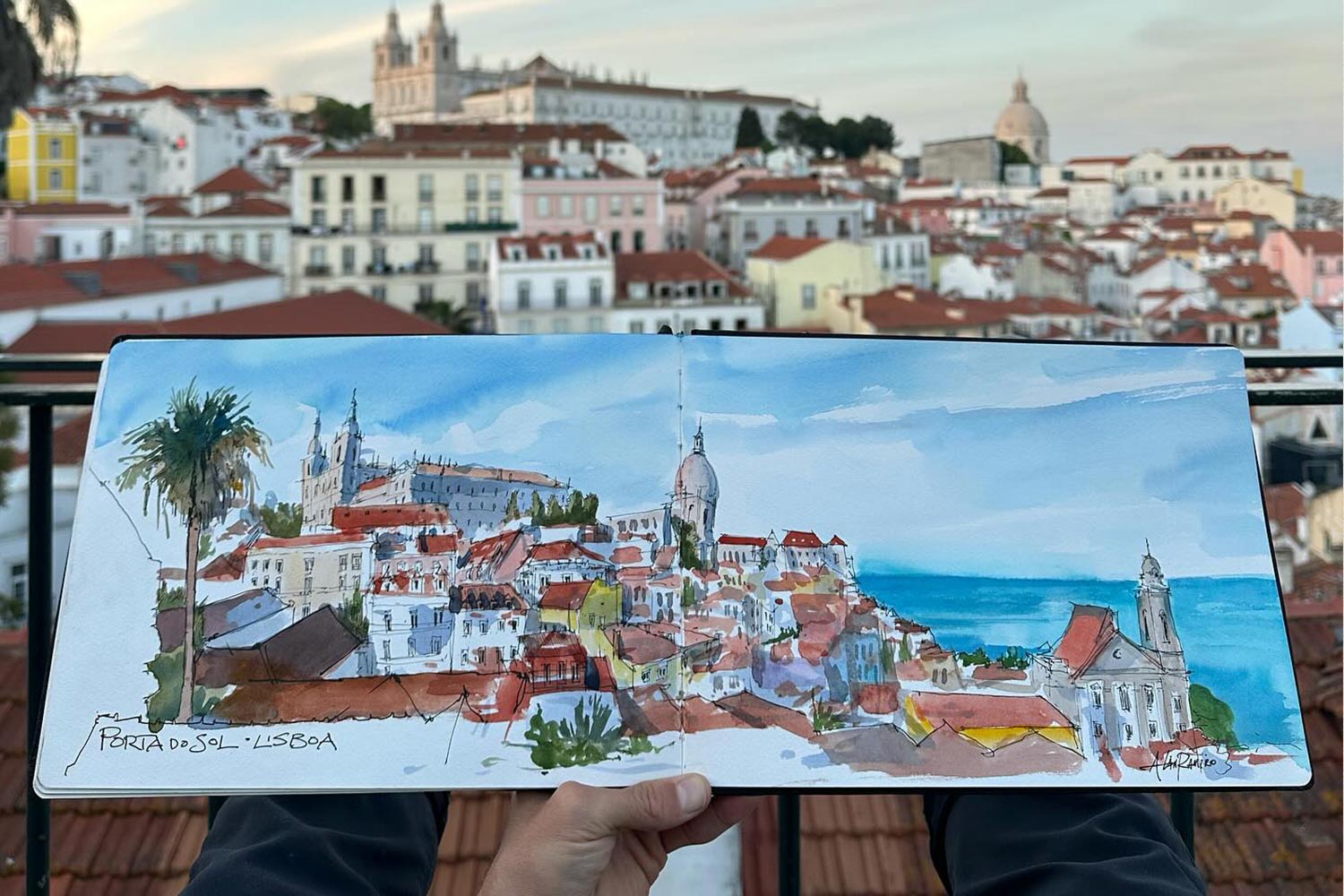 Colorful sketch of Portas do Sol, Lisboa, Portual held in front of the view