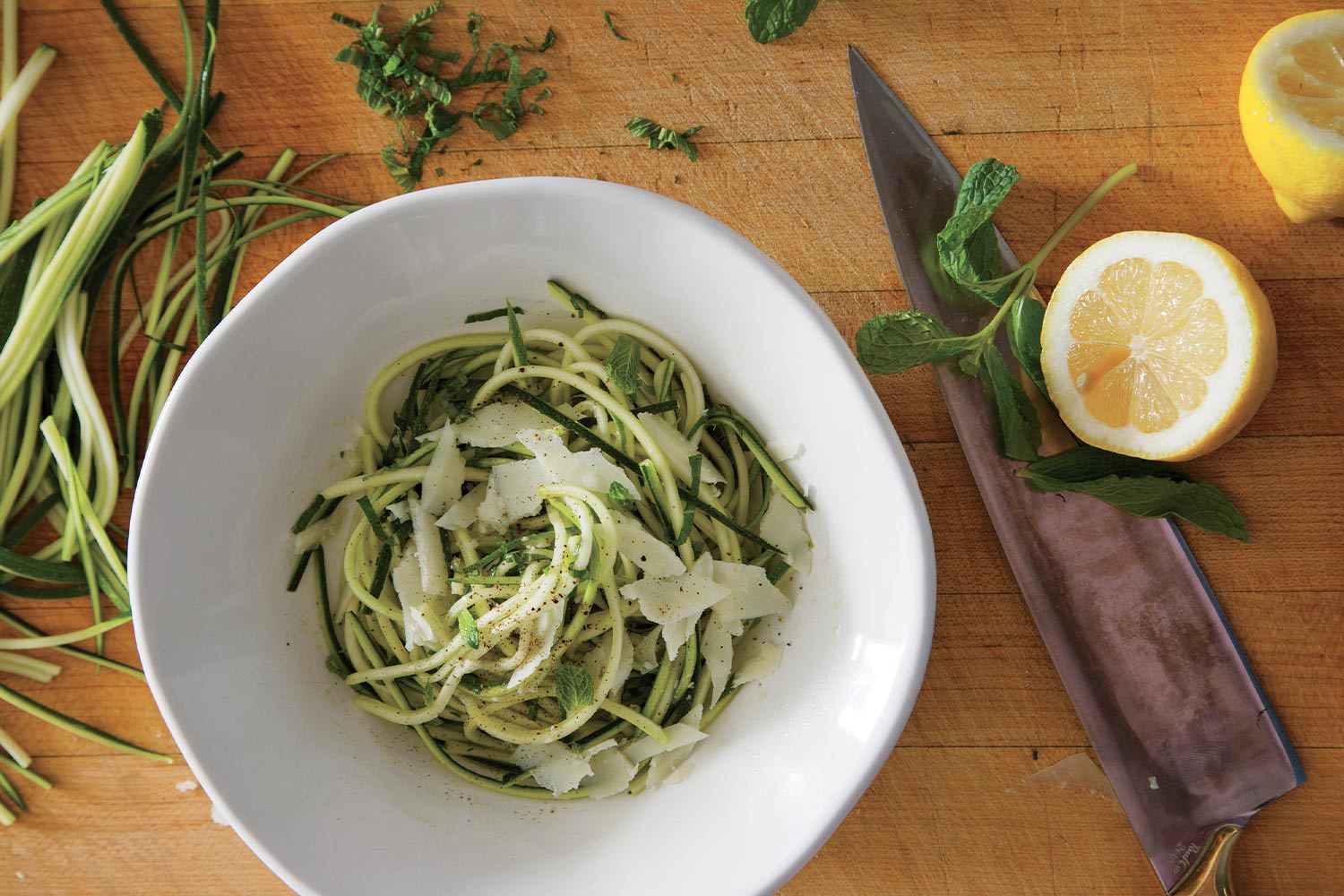 Zucchini salad with mint and lemons in a white bowl