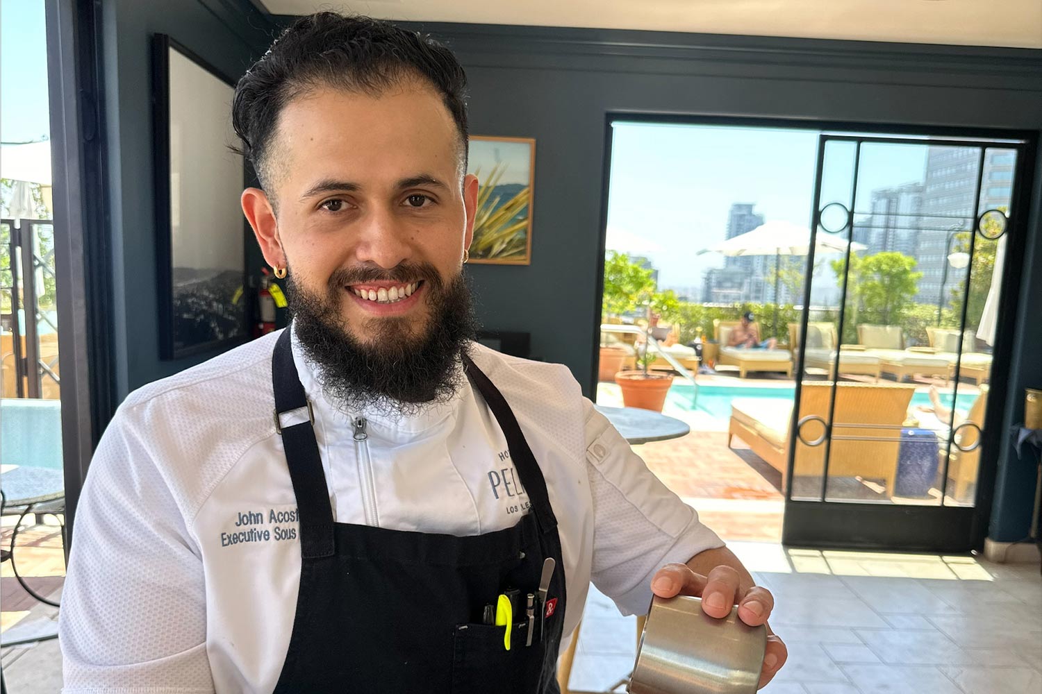 Chef Acosta poses for picture in chef jacket and apron