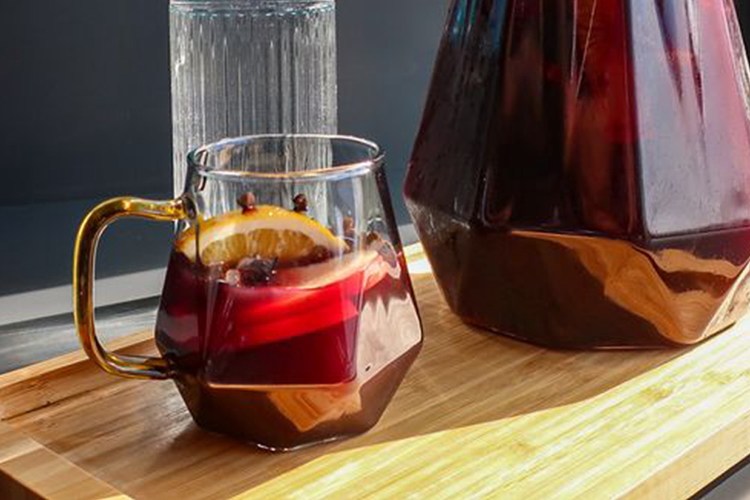 Red sangria in geometric cup and pitcher on a cutting board