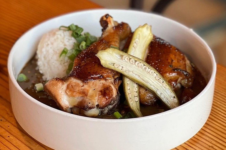 A bowl with soup and toppings inside